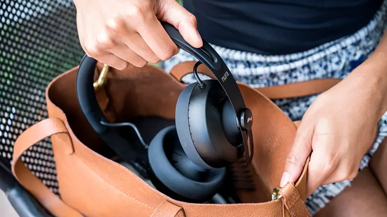 A person placing the Nuraphones in a bag