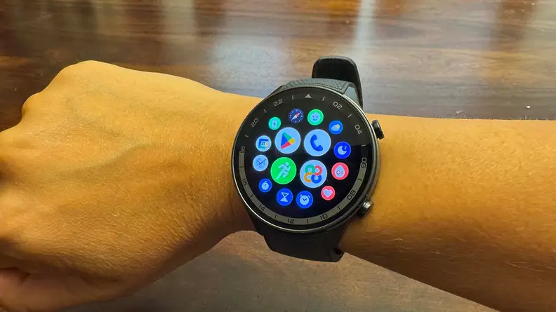 A hand with the watch on its wrist displaying the home menu.
