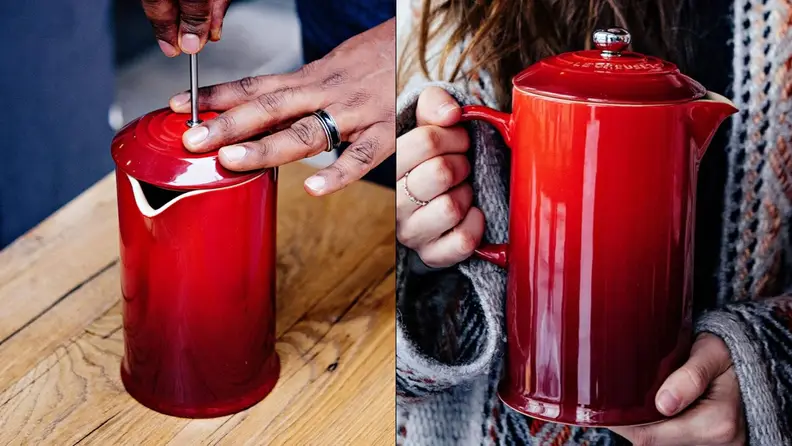 Two people holding the red stoneware Le Creuset French press