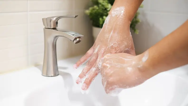 Two hands soaped up and being thoroughly washed, presumably for at least 20 seconds.
