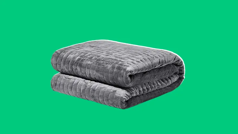 Grey gravity weighted blanket on a dark green background