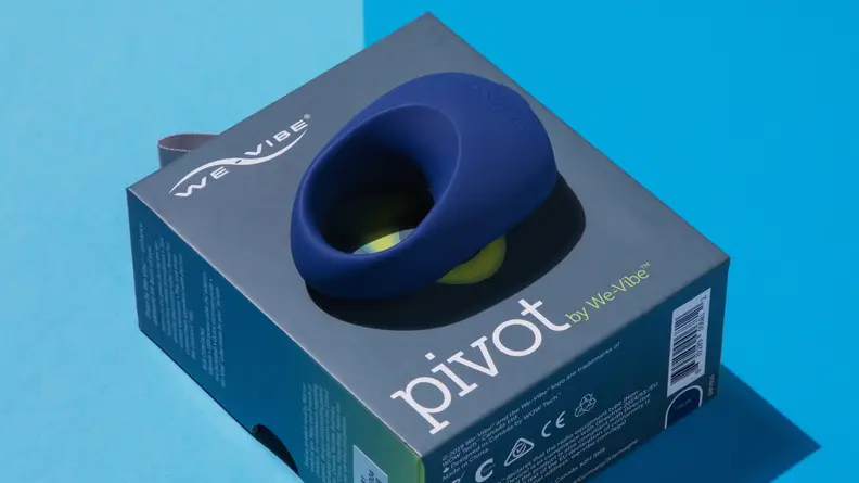A blue We-Vibe Pivot vibrating cock ring on top of cardboard box.