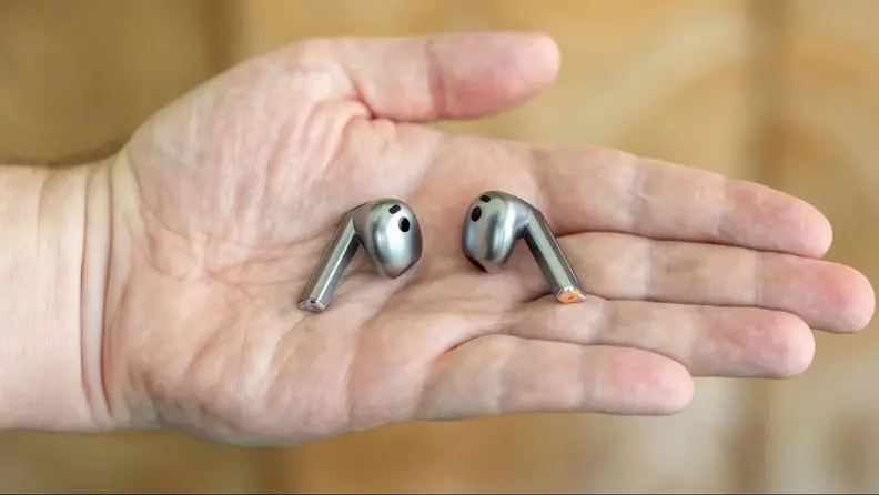 Close-up of a hand holding up the earbuds.
