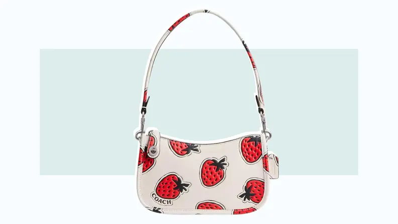 A white leather purse that features a strawberry print.