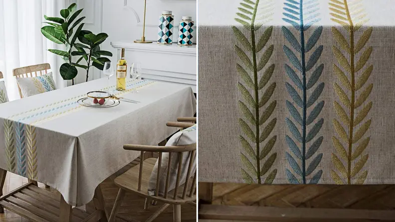 Product shot of blue, yellow and green embroidered tablecloth.