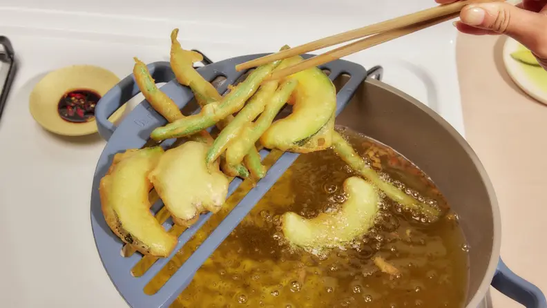 A blue Perfect Pot and matching Fry Deck being used to deep-fry vegetable tempura.