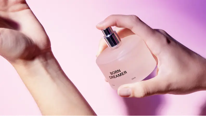 Spraying a bottle of Born Dreamer on a wrist.