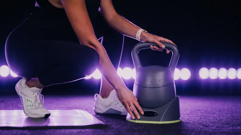 woman using jaxjox adjustable kettlebell