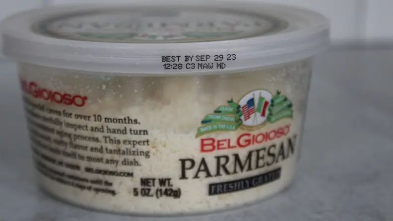 Plastic container filled with Parmesan cheese.
