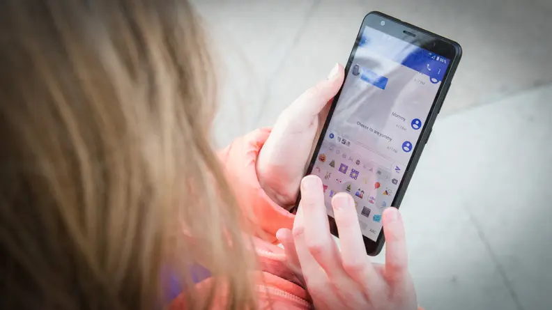 A child texts on a cell phone