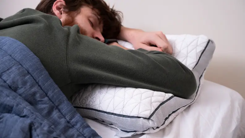 a man sleeps on the Coop Home Goods Eden pillow