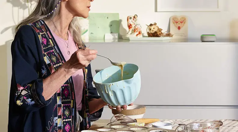 Woman cooking in kitchen with Echo Dot