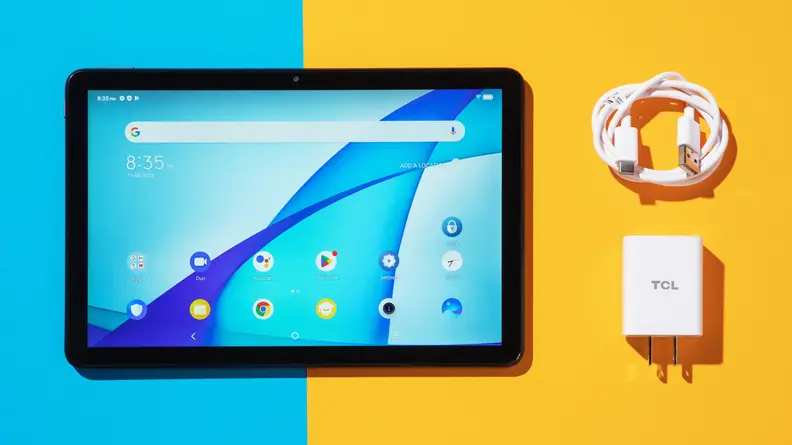 TCL Tab 10s tablet sitting next to charger block and power cord.