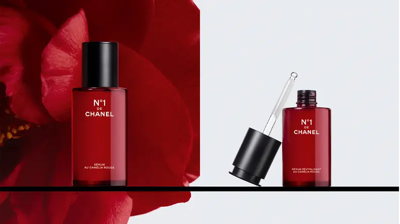 On the left: A red bottle of serum with a red flower in the background. On the right: A red bottle of serum uncapped with the dropper to the side of the bottle.