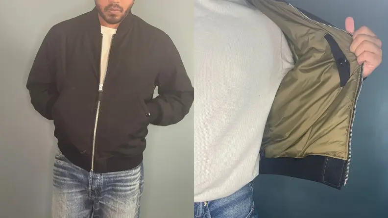 Man standing in buck mason bomber jacket.