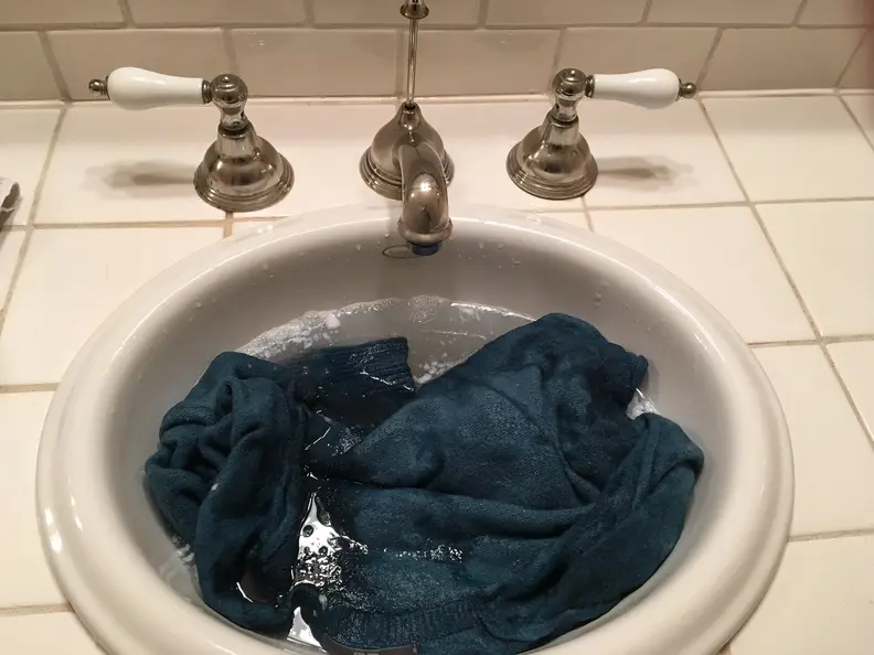 Soak sweater in lukewarm water and conditioner