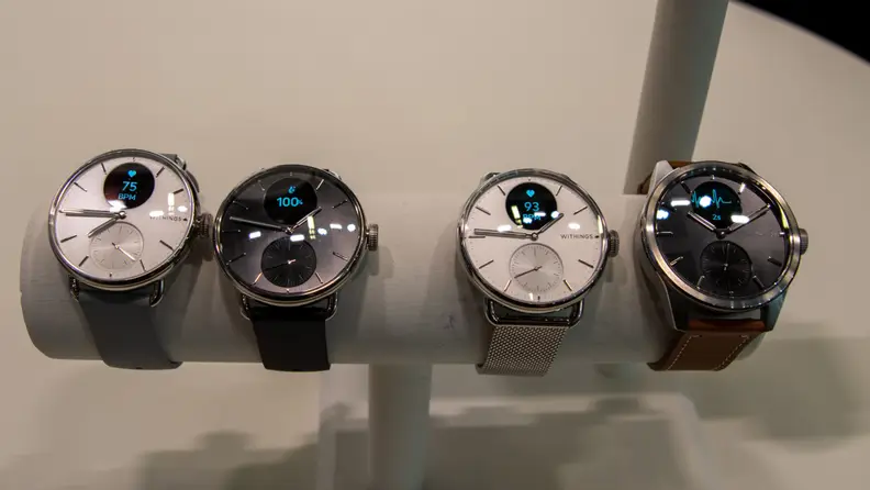 Closeup of four fitness tracking wrist watches on a stand.