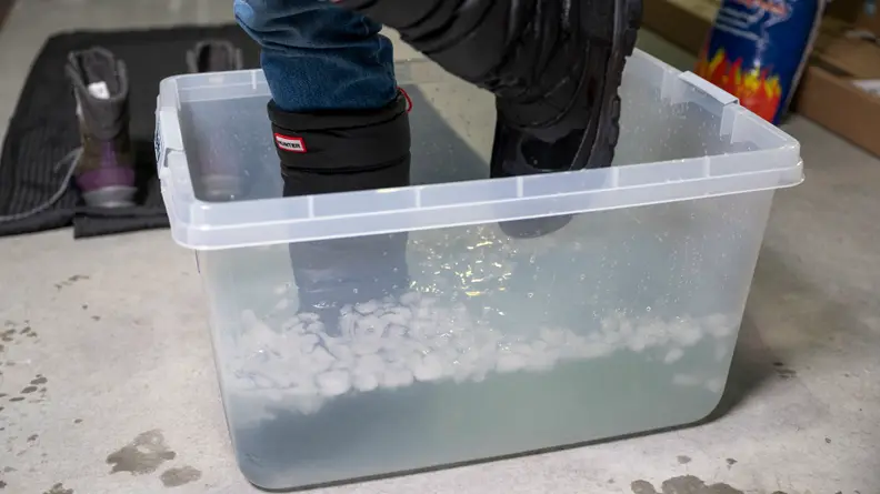 A woman walks in place, in a tank of ice water and slush, to test a pair of winter boots.