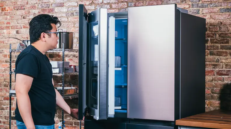 A person opens a refrigerator door