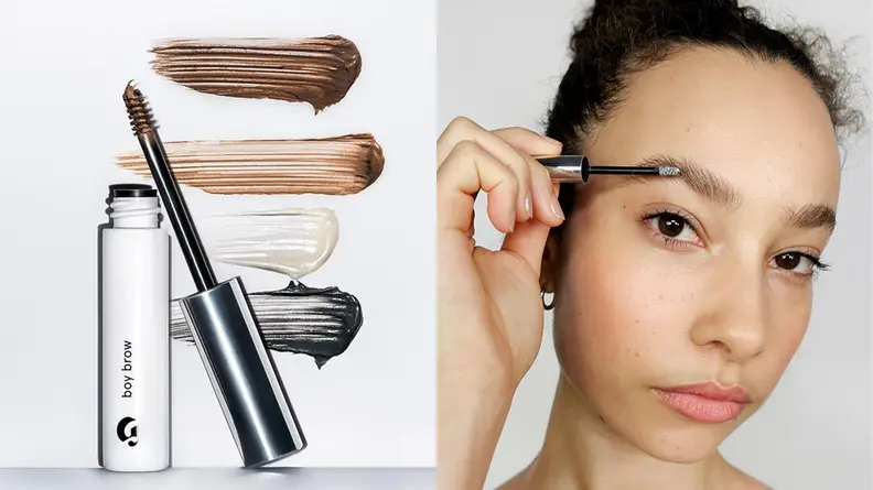 On the left: The small Glossier Boy Brow tube stands with its small brush leaned up against it. Swatches of each color of the brow gel are in the background. On the right: A person brushes through their eyebrow hairs with Boy Brow.