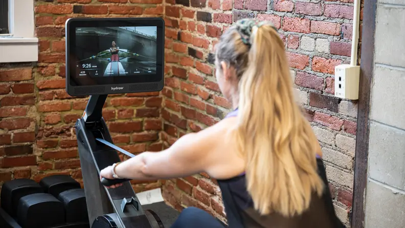 The back view of a person using the Hydrow Wave rower.