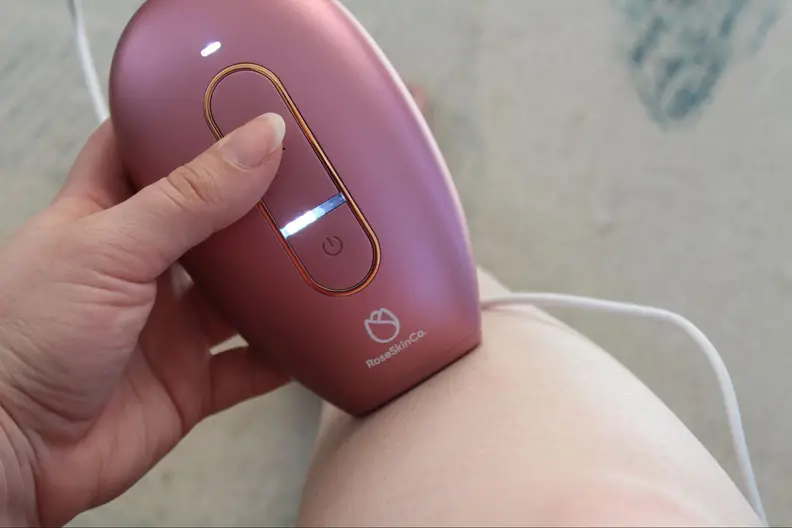 The RoseSkinCo Lumi permanent hair removal device being used on someone’s leg.