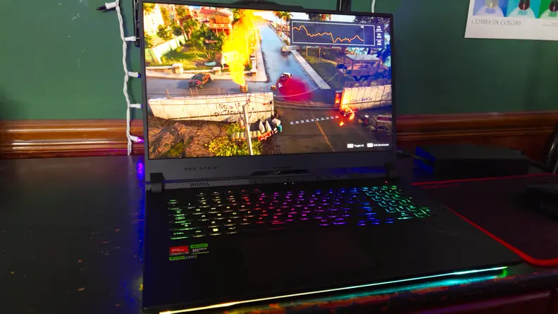 The Asus ROG Strix SCAR 17 open with a game on the screen, on a desk