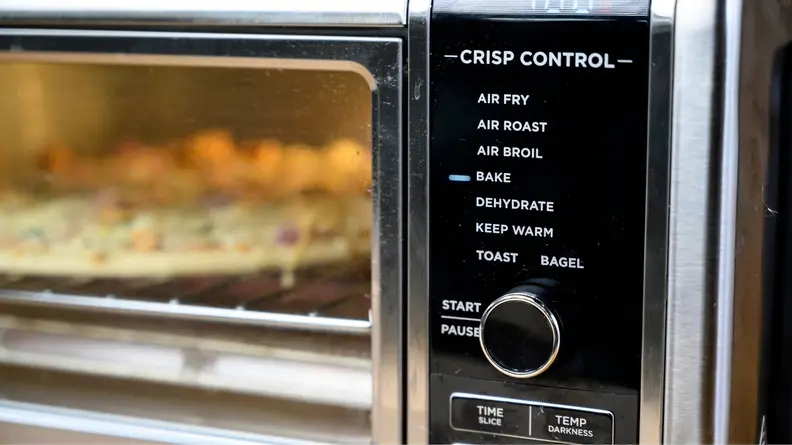 A pizza cooks in a Ninja Foodi oven