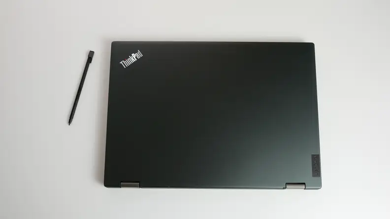 Closed Lenovo ThinkPad L13 Yoga Gen 4 next to stylus pen.