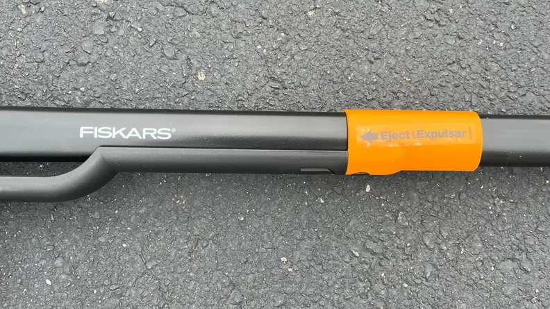 Close-up of the Fiskars logo and the orange eject mechanism.