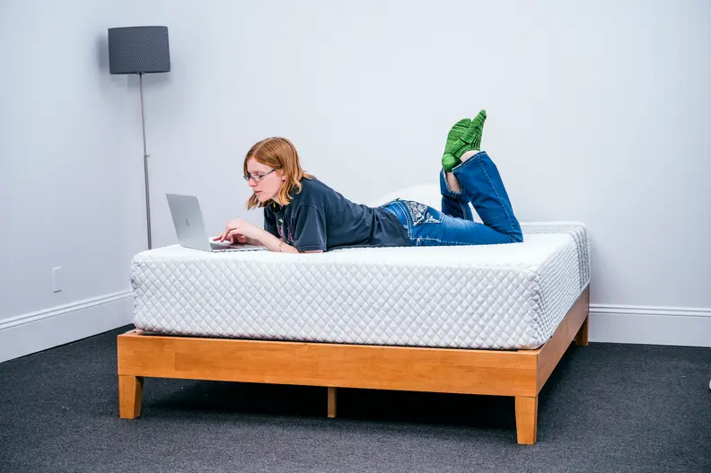 a woman lies on the Leesa mattress in a bedroom