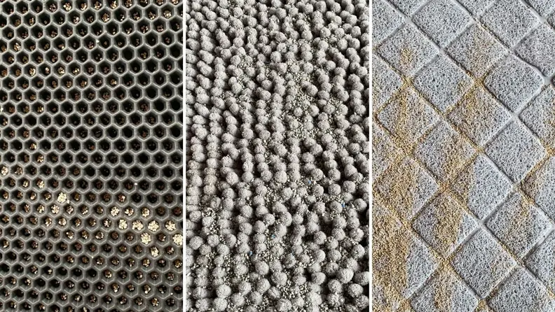 A close up of litter spread across three different cat litter mats.