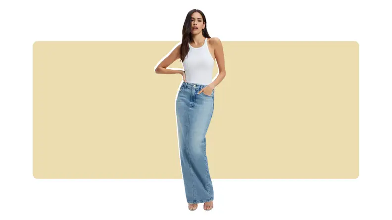 A model wearing a floor-length blue denim skirt and a white tank top.