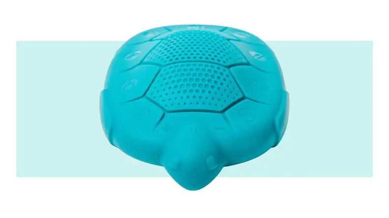 A turquoise turtle-shaped Zenimal sits with its back showing audio ports.