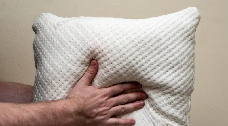 a person squeezes a pillow