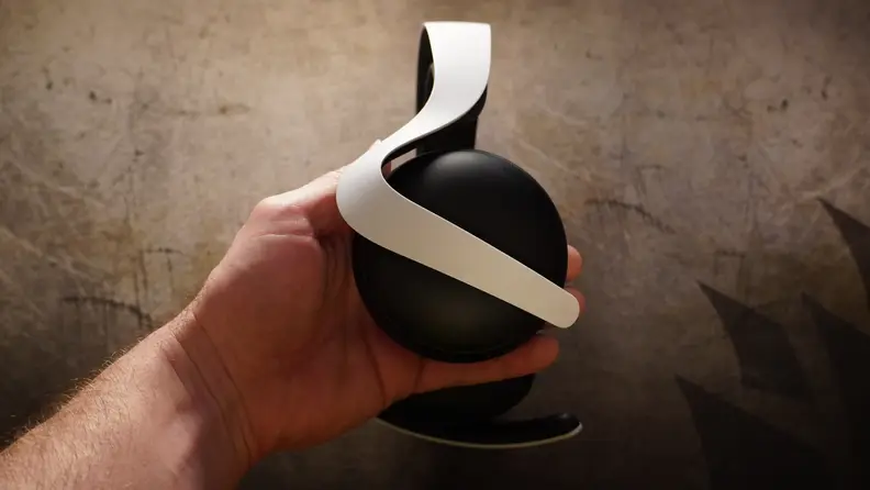 A hand holding the Sony Pulse Elite headphones.