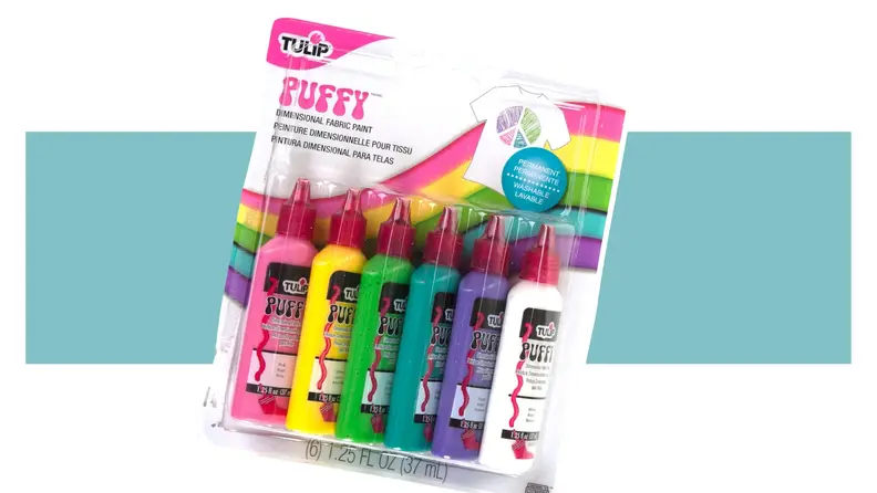 Bottles of Tulip puff paint in 6 different colors on a colorful background