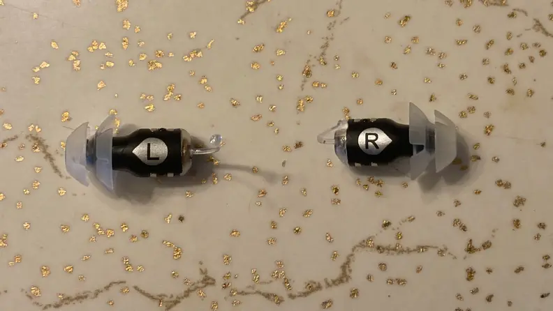 Pair of Eargo SE hearing aids on countertop surface.