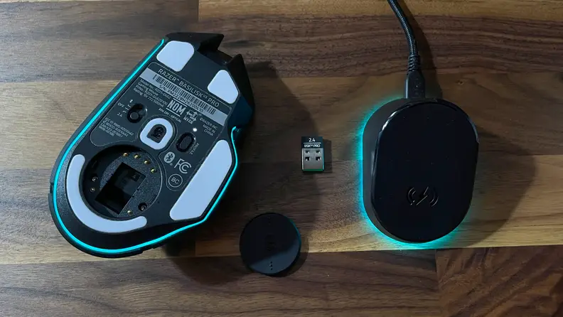 The bottom part of the mouse next to the wireless dongle and USB stick.