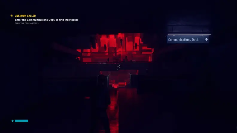 A person stands in a dark hallway illuminated by red lights