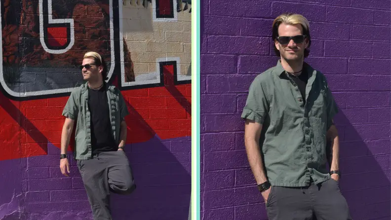 A man modeling a button up shirt and an undershirt in an urban setting.