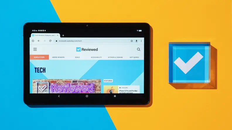 TCL Tab 10s tablet sitting next to blue acrylic paperweight with a white checkmark in the middle.