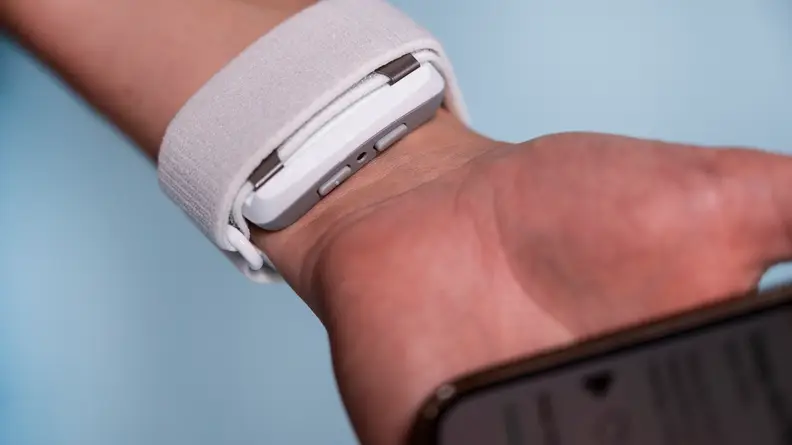A person wears an Apollo Neuro on the inside of the wrist.
