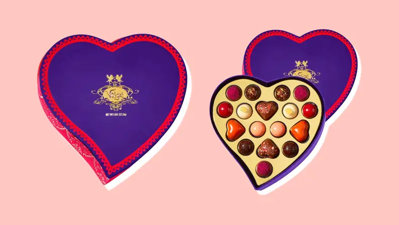 Closed and open box of Vosges chocolate truffles on a pink background