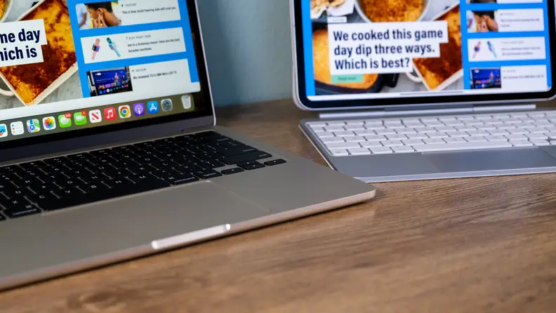 A MacBook Air and an iPad Pro sit on a desk and show off their keyboards