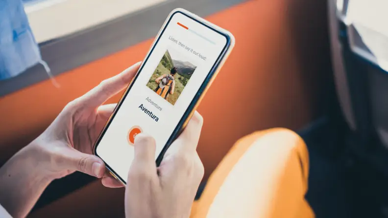 A person's hands hold a phone with the Babbel app open.