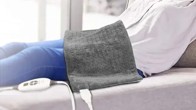 A person with the Pure Enrichment's XL heating pad on their lap.