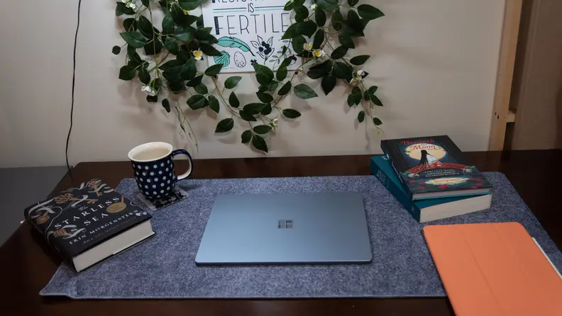The laptop is closed on the desktop.