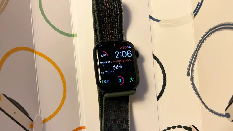 An Apple Watch Series 8 sits in the box with its display on.