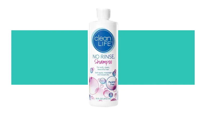 A bottle of No-Rinse Shampoo in front of a background.